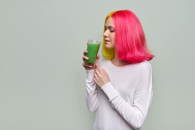 Dziewczyna pijąca zielone smoothie.